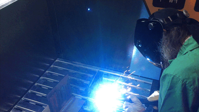 Demonstration of a machine operator using a FumeXtractors downdraft table while working on a welding project.