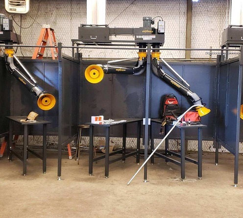 FumeXtractors welding booths and fume arms installed in a welding workshop.